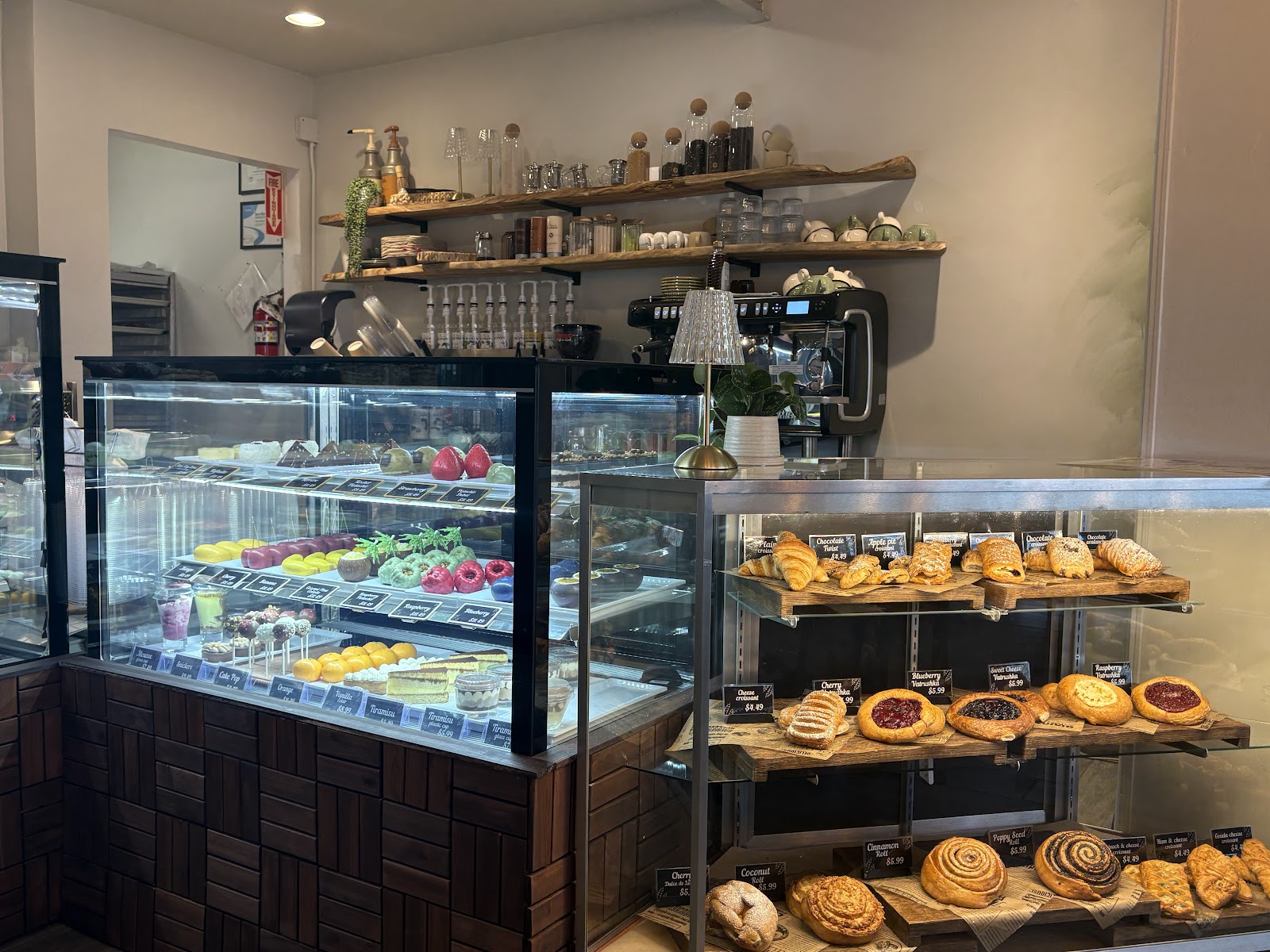 The café counter and espresso bar with warm wood shelves